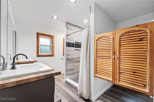 bathroom featuring vanity, hardwood / wood-style floors, a textured ceiling, and a shower with curtain