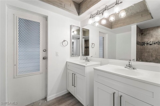 bathroom with vanity, hardwood / wood-style flooring, and a tray ceiling