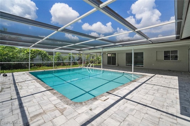 view of swimming pool with glass enclosure and a patio area