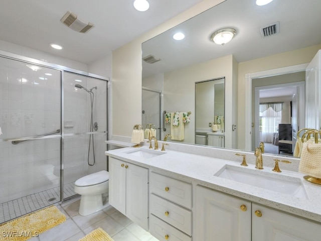 bathroom featuring toilet, vanity, tile patterned flooring, and a shower with door