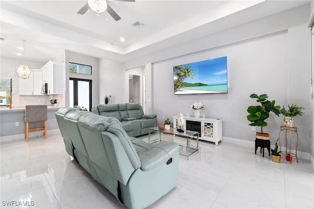 living room with ceiling fan with notable chandelier