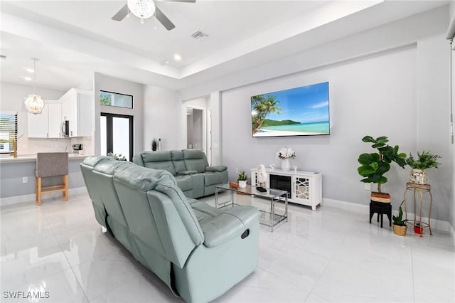 1114 Clayton Ave, Lehigh Acres, FL 33972 - living room featuring a tray ceiling and ceiling fan with notable chandelier