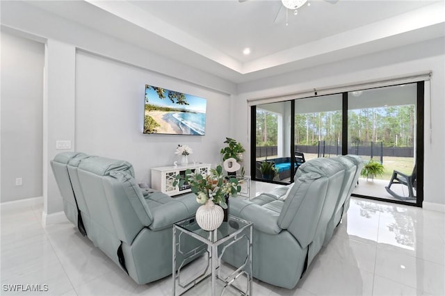 living room featuring light tile patterned floors and a tray ceiling