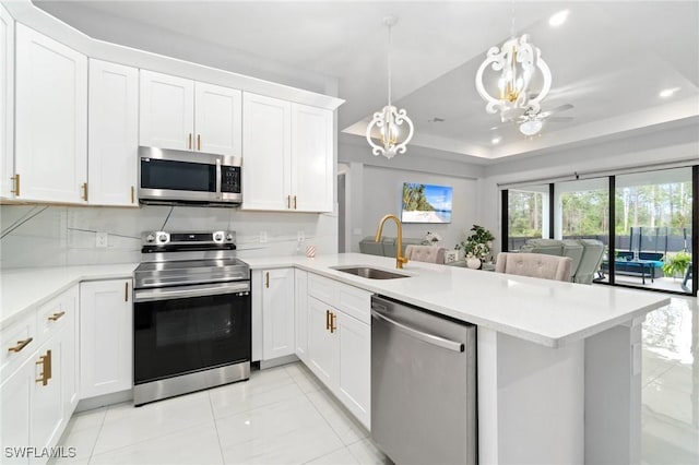 1114 Clayton Ave, Lehigh Acres, FL 33972 - kitchen featuring appliances with stainless steel finishes, sink, pendant lighting, and kitchen peninsula