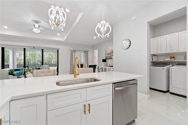 kitchen featuring sink, dishwasher, washing machine and dryer, and hanging light fixtures