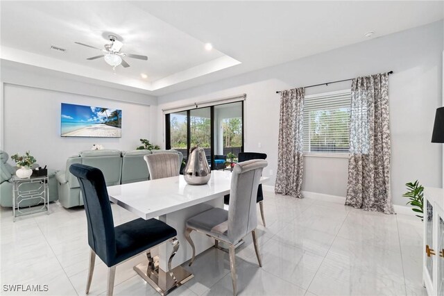 1114 Clayton Ave, Lehigh Acres, FL 33972 - dining room with ceiling fan, a raised ceiling, and a wealth of natural light