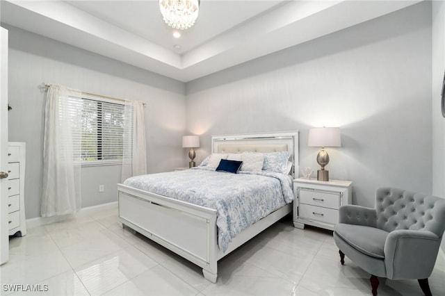 bedroom featuring a raised ceiling and a notable chandelier