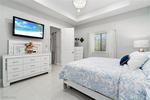 bedroom with a raised ceiling and an inviting chandelier