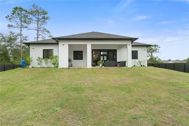 rear view of house featuring a lawn