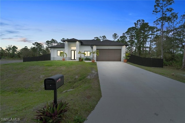 view of front of property featuring a garage and a lawn