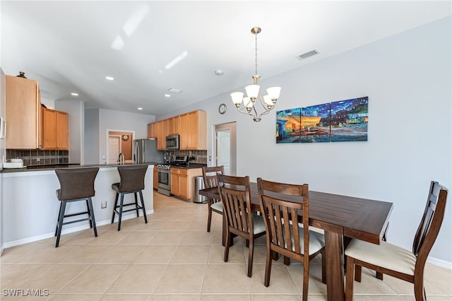 tiled dining room with a chandelier and sink