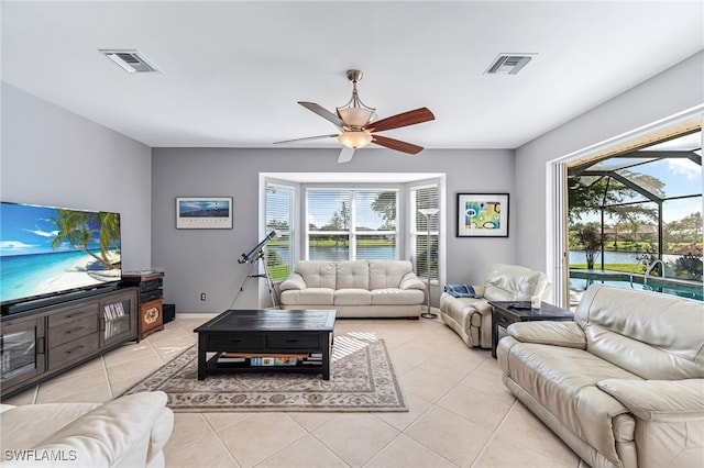 living room with a water view, plenty of natural light, and light tile patterned floors