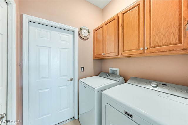 laundry room with cabinets and washer and clothes dryer