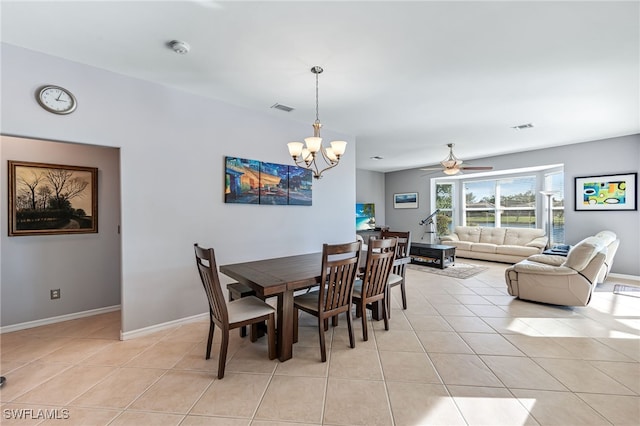 tiled dining room featuring ceiling fan with notable chandelier