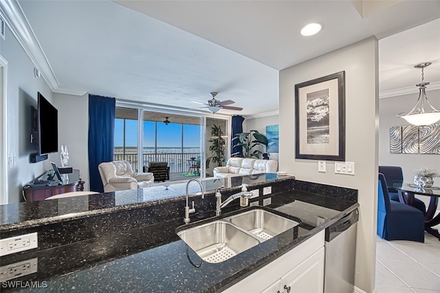 kitchen featuring dark stone countertops, stainless steel dishwasher, sink, light tile patterned flooring, and white cabinets