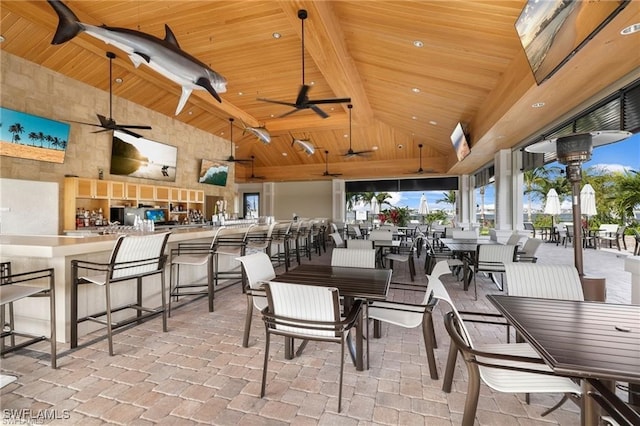 dining area with ceiling fan, beamed ceiling, wood ceiling, and high vaulted ceiling