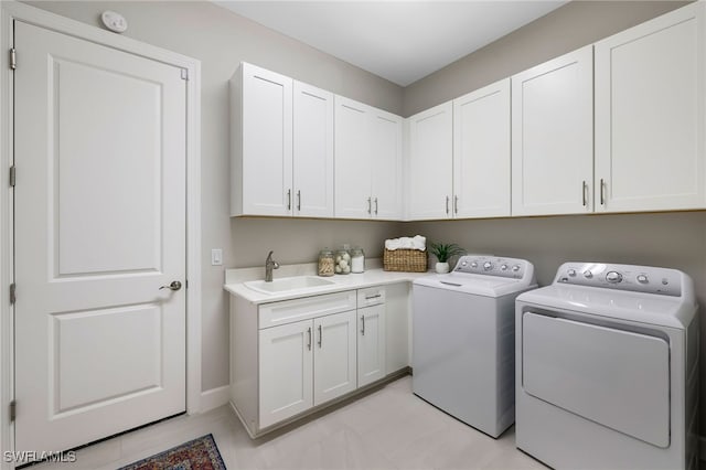 laundry area with cabinets, independent washer and dryer, and sink