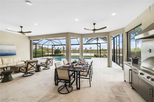 interior space with a water view, an outdoor hangout area, exterior kitchen, and a lanai