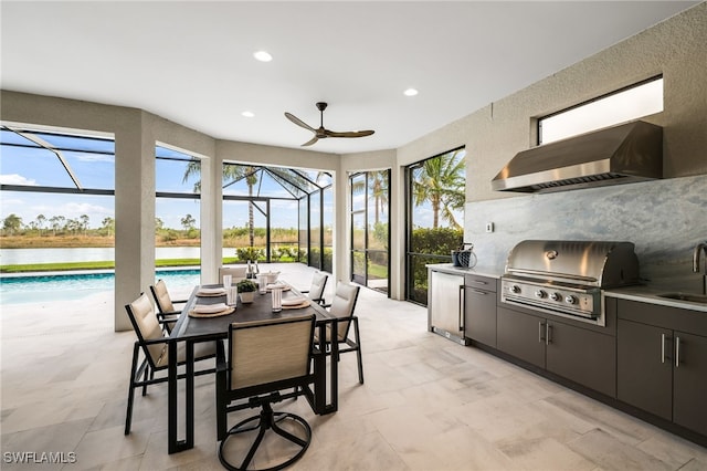 view of patio / terrace with a lanai, sink, a water view, and area for grilling