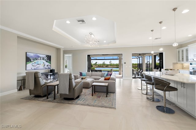 living room featuring light tile patterned floors, crown molding, and a tray ceiling