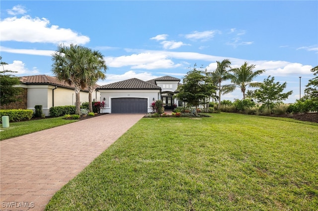 mediterranean / spanish-style home with a garage and a front lawn