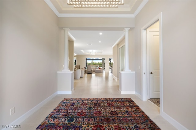 corridor with light tile patterned floors, ornamental molding, and ornate columns