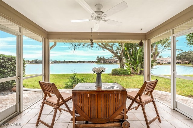 sunroom featuring ceiling fan and a water view