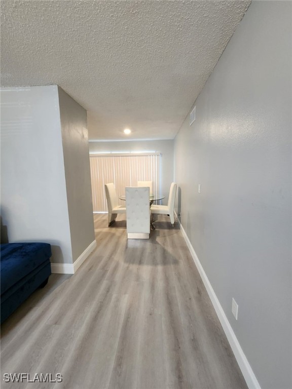 interior space with a textured ceiling and light wood-type flooring