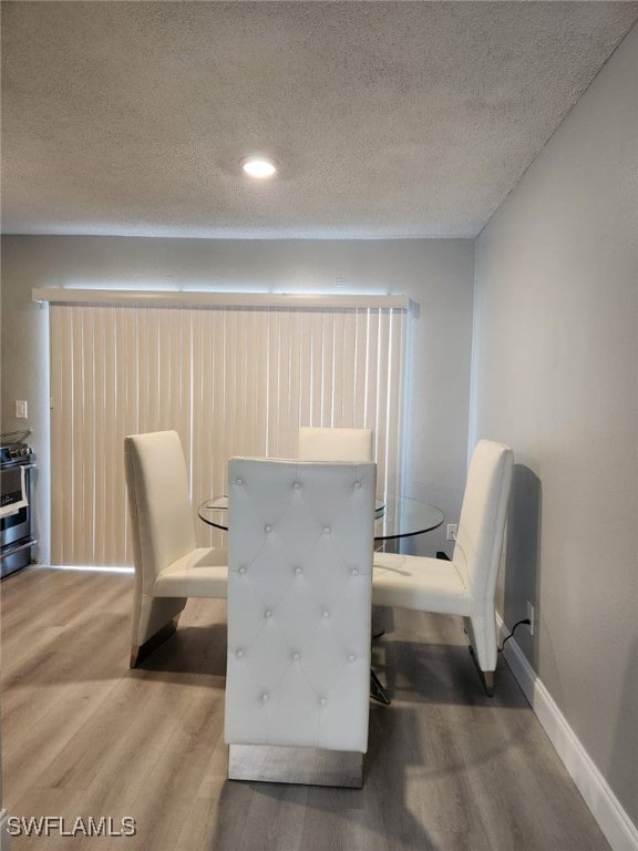 dining space featuring a textured ceiling and wood-type flooring