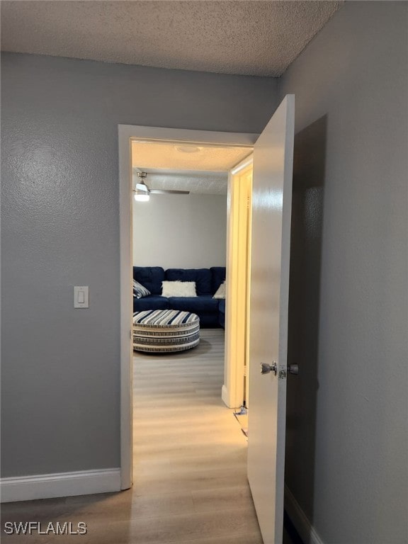 hallway featuring hardwood / wood-style flooring and a textured ceiling