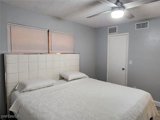 bedroom with ceiling fan and a textured ceiling