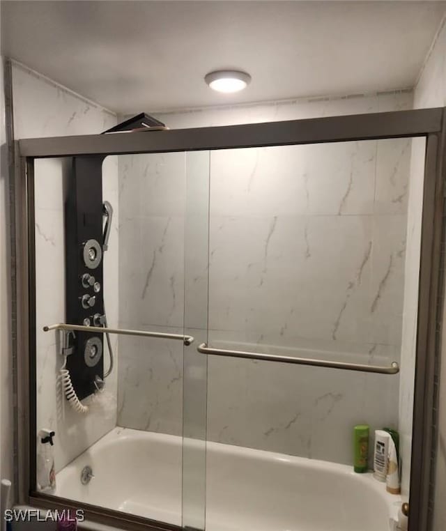 bathroom with combined bath / shower with glass door