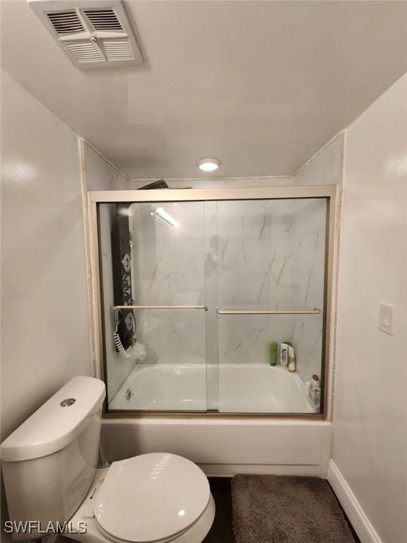 bathroom featuring toilet and combined bath / shower with glass door