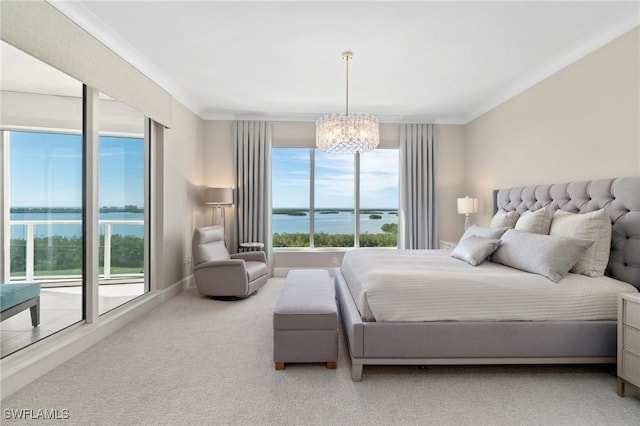 bedroom with a water view, crown molding, an inviting chandelier, and carpet