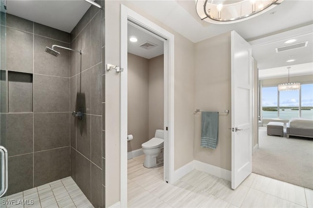 bathroom featuring a water view, tiled shower, toilet, and a chandelier