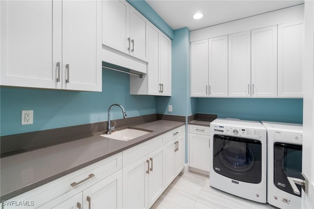 laundry room featuring cabinets, sink, and washer and dryer