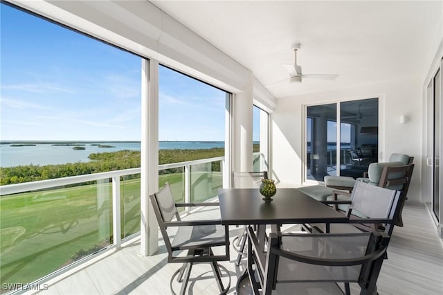 sunroom / solarium with a water view and ceiling fan