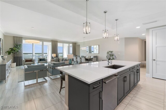 kitchen with pendant lighting, dishwasher, an island with sink, sink, and a breakfast bar area