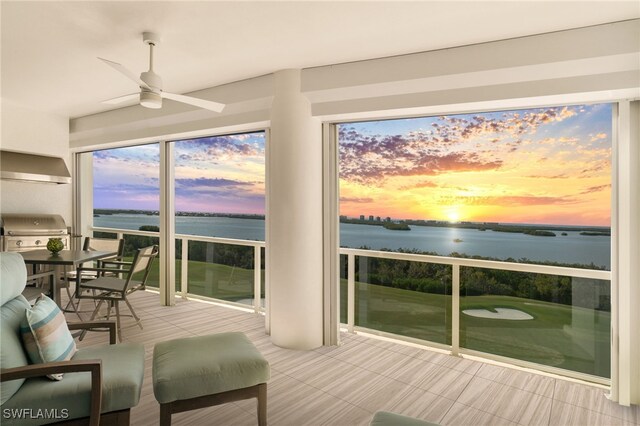 sunroom / solarium with a water view and ceiling fan