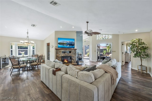 living room featuring lofted ceiling, ceiling fan with notable chandelier, a fireplace, and dark hardwood / wood-style flooring