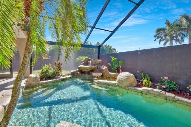 view of swimming pool with pool water feature and glass enclosure