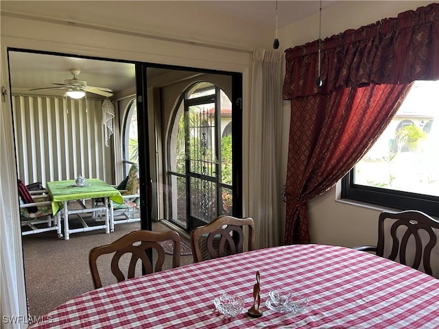 carpeted dining area with ceiling fan