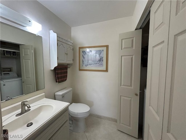 bathroom with vanity, toilet, washer / dryer, and tile patterned flooring