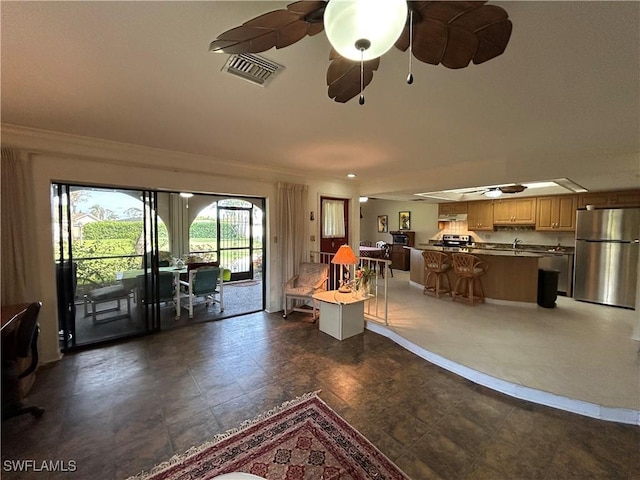 living room with sink, crown molding, and ceiling fan