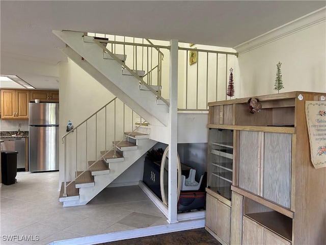 stairs featuring tile patterned flooring and ornamental molding