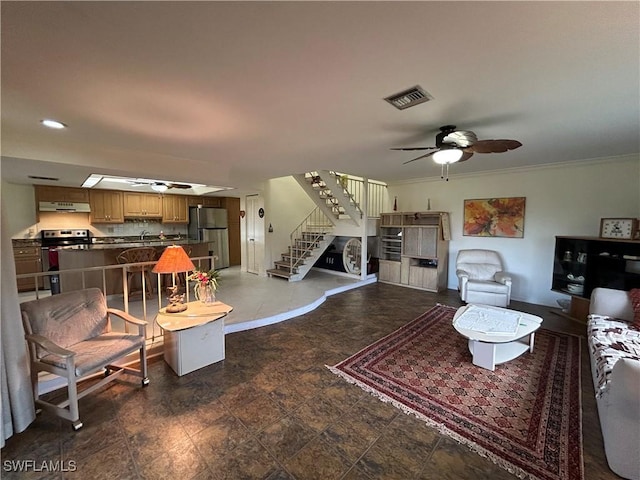 living room with ornamental molding, sink, and ceiling fan