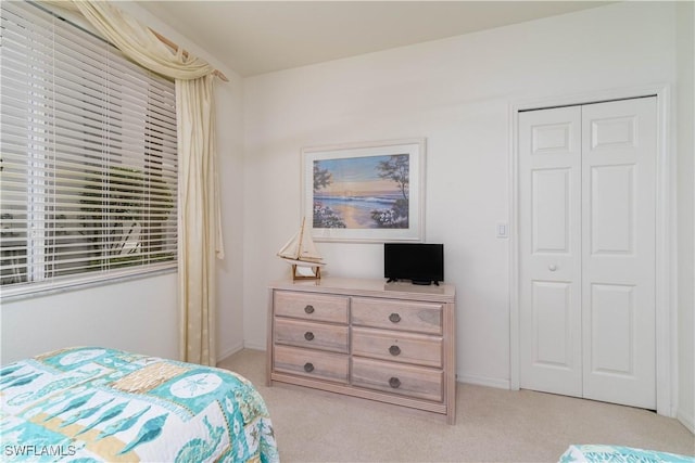 bedroom featuring a closet and light colored carpet