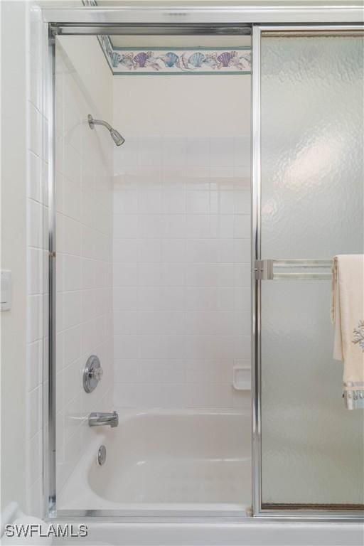 bathroom with bath / shower combo with glass door