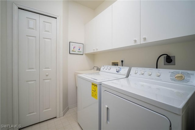 washroom with cabinets and washer and dryer