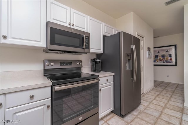 8461 Southbridge Dr Unit 4, Estero, FL 33967 - kitchen featuring appliances with stainless steel finishes, white cabinetry, and light countertops